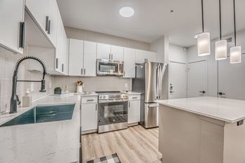White kitchen with island and stainless steel appliances